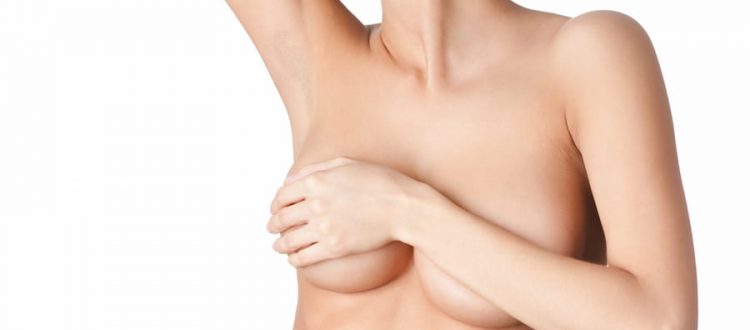 Una chica se contonea tapándose el pecho recién operado para aumentar el tamaño de sus mamas